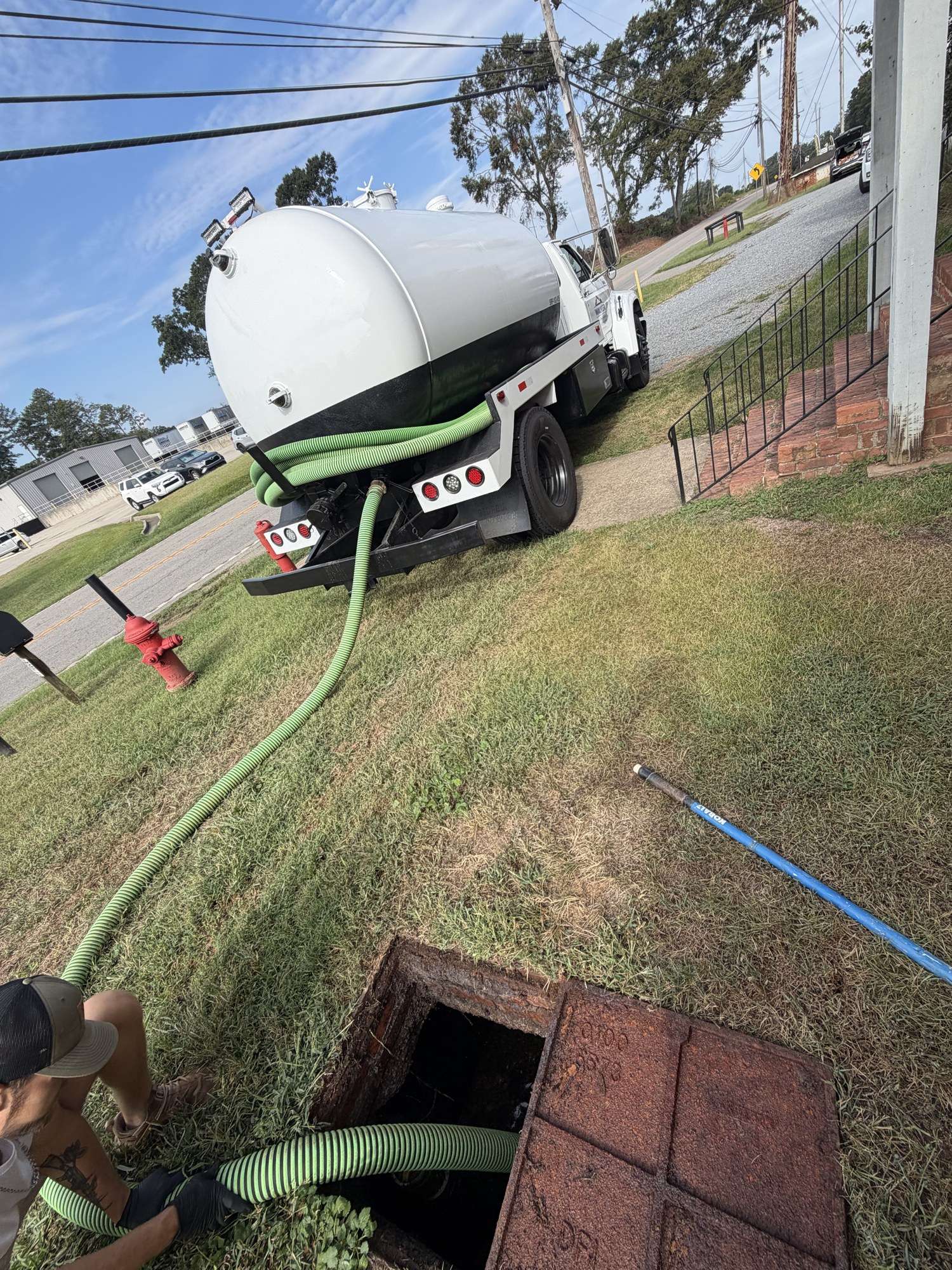 Walker Septic pump truck at a job with the hose run to an open tank