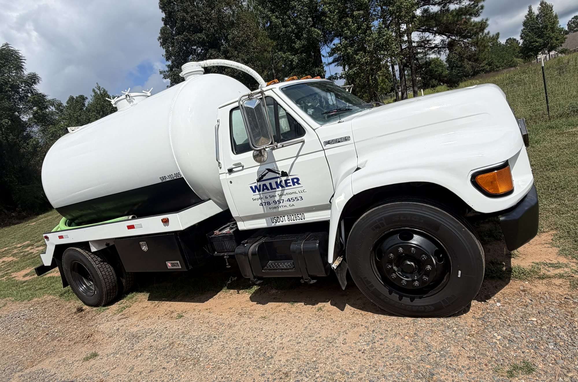 Walker Septic pump truck parked in a yard